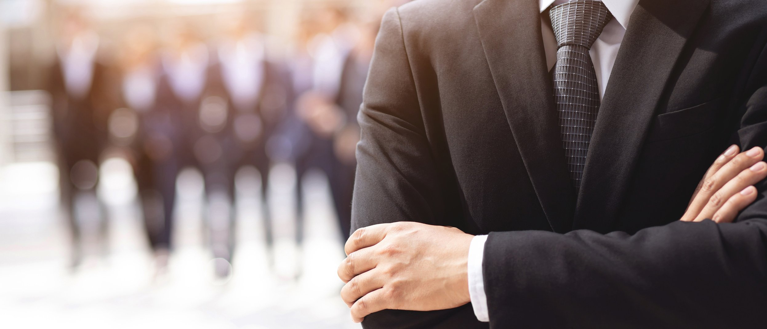 Businessperson in Black Suit with Crossed Arms